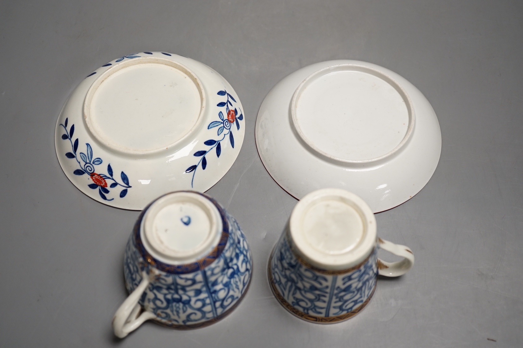 A Worcester coffee cup and saucer of rare Sevres shape with entwined handle painted with the Royal Lily pattern with an unusual central design and a Worcester conical coffee cup and saucer painted with another version of